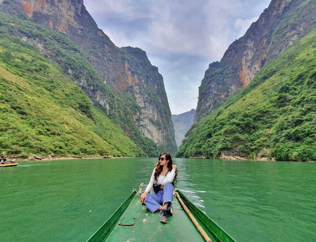 Du khách ngồi thuyền trên sông Nho Quế  thưởng ngoạn thiên nhiên tuyệt sắc.