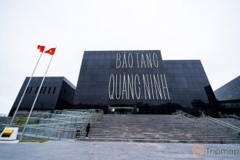 Bảo tàng Quảng Ninh, nền đường màu xám, cầu thang màu xám, nhà kính màu đen, lá cờ việt nam, ảnh chụp ban ngày