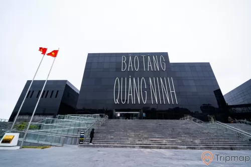 Bảo tàng Quảng Ninh, nền đường màu xám, cầu thang màu xám, nhà kính màu đen, lá cờ việt nam, ảnh chụp ban ngày