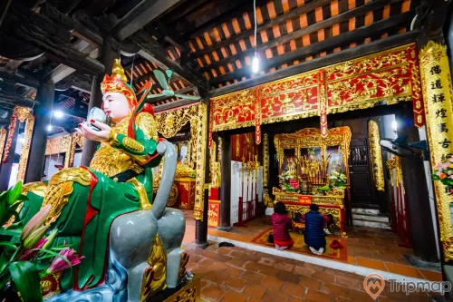 Chùa Long Tiên, tượng hộ pháp, nền gạch màu đỏ, người đang cầu nguyện, gian thờ có hoa văn màu vàng, trần nhà bằng gỗ màu nâu