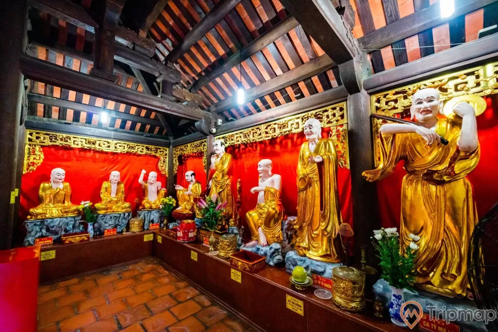 Chùa Long Tiên, nhiều tượng thờ màu vàng, nền gạch màu đỏ, lư hương, lọ hoa, tấm rèm màu đỏ, trần nhà bằng gỗ màu nâu