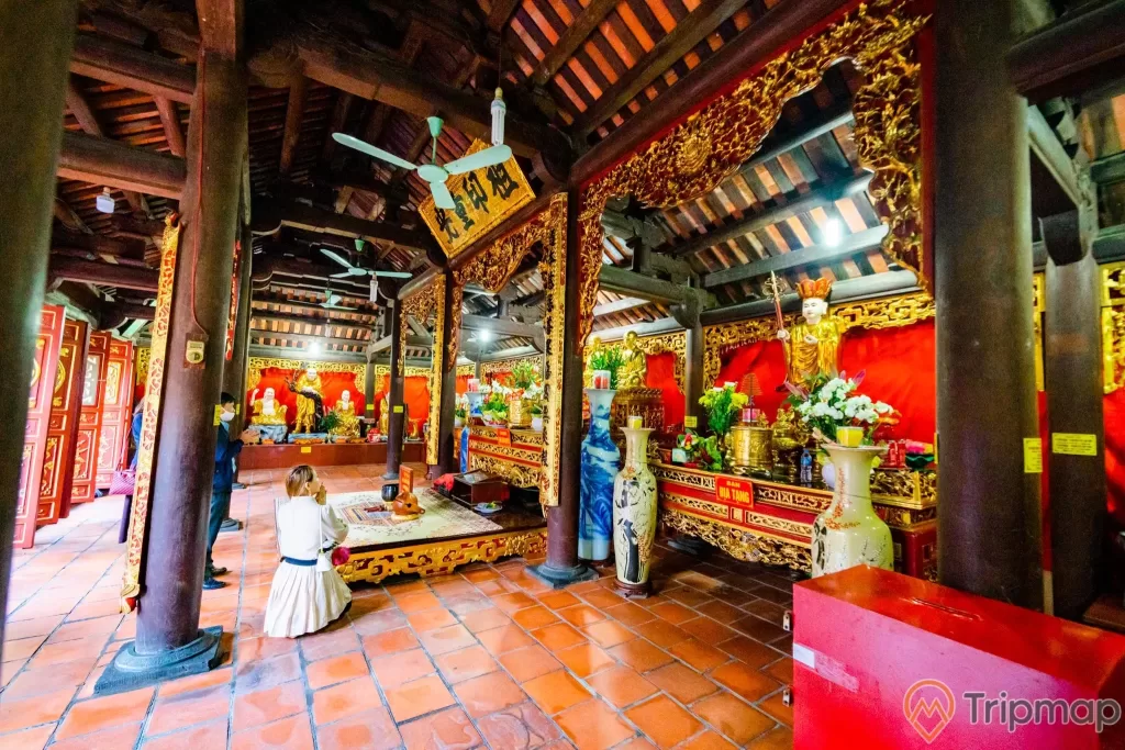 Chùa Long Tiên, Tổ Đường, nền gạch màu đỏ, người đang cầu nguyện, lọ hoa, nhiều cột nhà màu nâu, cây quạt trần, trần nhà bằng gỗ màu nâu