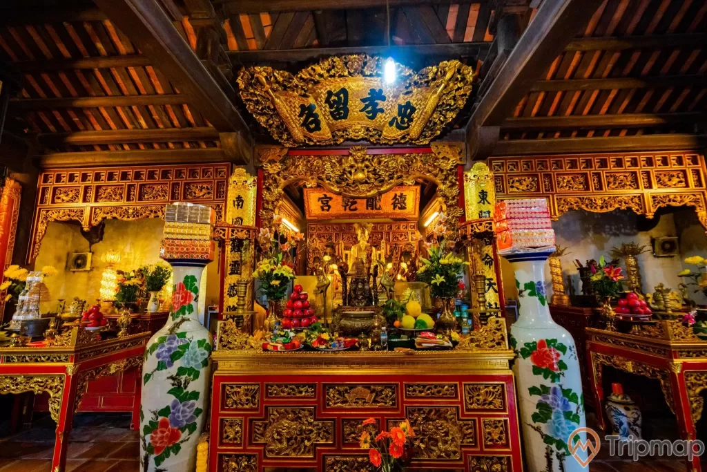 Đền thờ Đức Ông Trần Quốc Nghiễn, gian thờ Trần Quốc Nghiễn, 2 bình hoa to màu trắng, nhiều hoa văn, nhiều chữ hán, trần nhà bằng gỗ màu nâu