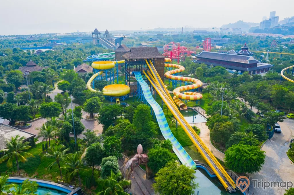 Khu vui chơi giải trí Sun World Ha Long Complex, công viên nước Typhoon Water Park, máng trượt màu xanh và vàng, nhiều cây xanh, ảnh chụp từ trên cao, ảnh chụp ban ngày