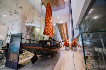 Bảo tàng Quảng Ninh, mô hình thuyền buồm, biển cả và tự nhiên, cánh buồm màu cam, thuyền bằng gỗ, tủ kính, nền nhà màu nâu nhạt, bảng chỉ dẫn màu đen
