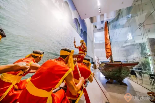Bảo tàng Quảng Ninh, biển cả và tự nhiên, mô hình người đang chèo thuyền, nhiều người mặc áo đỏ đang chèo thuyền, mô hình thuyền buồm, nền nhà màu nâu nhạt