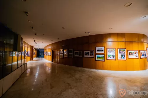 Bảo tàng Quảng Ninh, nơi lưu giữ những giá trị lịch sử, nhiều bức tranh được gắn trên bức tường bằng gỗ màu nâu, nền nhà bằng gạch có hoa văn, trần nhà màu trắng, hành làng dài
