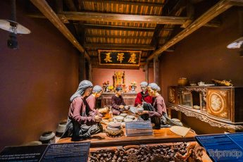 Khu tái hiện lịch sử hình thành mỏ than, bảo tàng Quảng Ninh, nhiều mô hình người đang ngồi ăn cơm, trần nhà bằng gỗ màu nâu, bức tường màu nâu