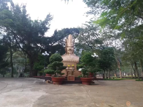 khuôn viên thờ cúng vua Hùng Vương tai khu du lịch Thác Đa, chậu cây cảnh trước tượng thờ, cây cối phía sau bức tượng, ảnh chụp ngoài trời
