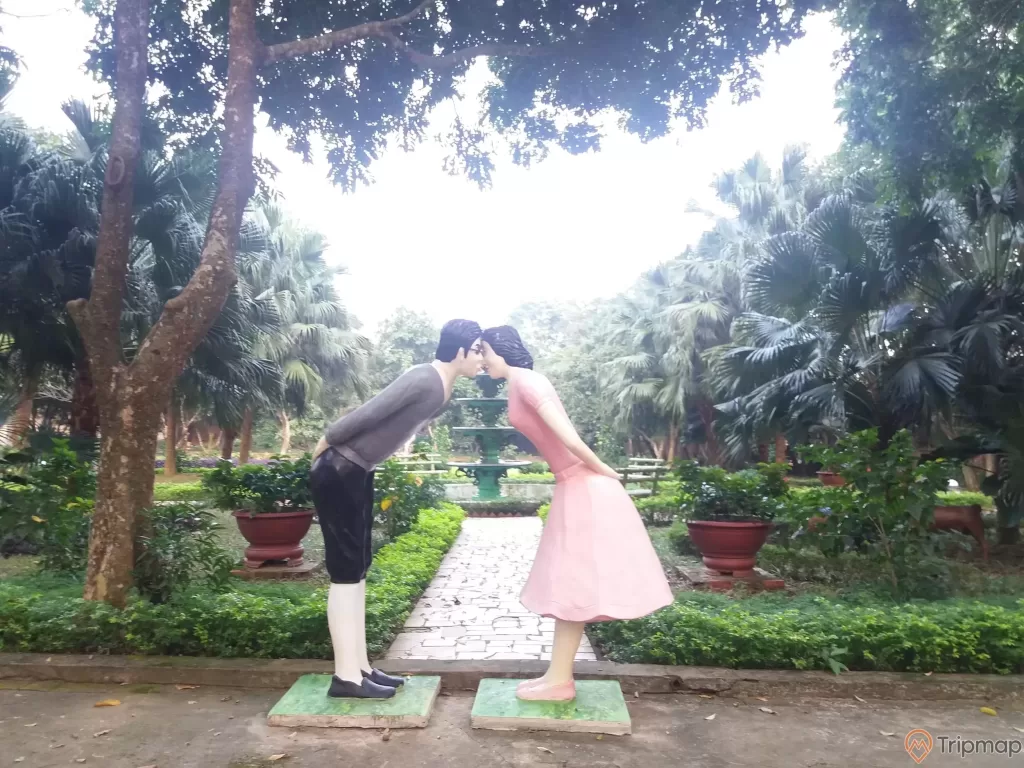 khu vườn tình yêu trong khu du lịch Thác Đa, 2 bức tượng nam nữ đang hôn nhau, 2 chậu cây cảnh và cây cối trong vườn