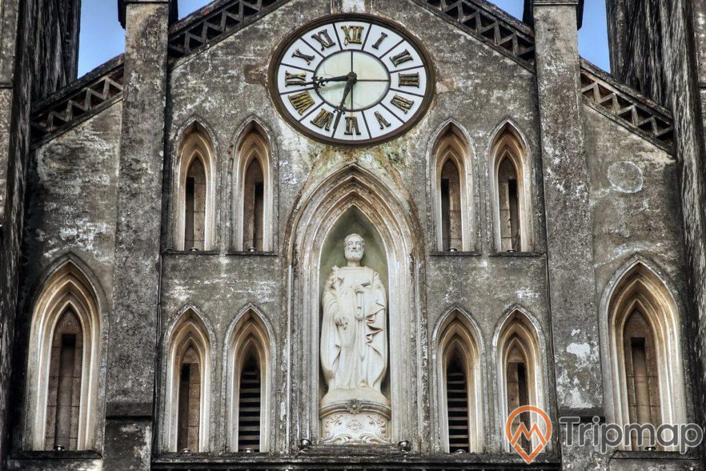 1 bức tượng thánh Giuse và 1 chiếc đồng hồ cổ ở chính giữa mặt tiền nhà thờ Lớn Hà Nội