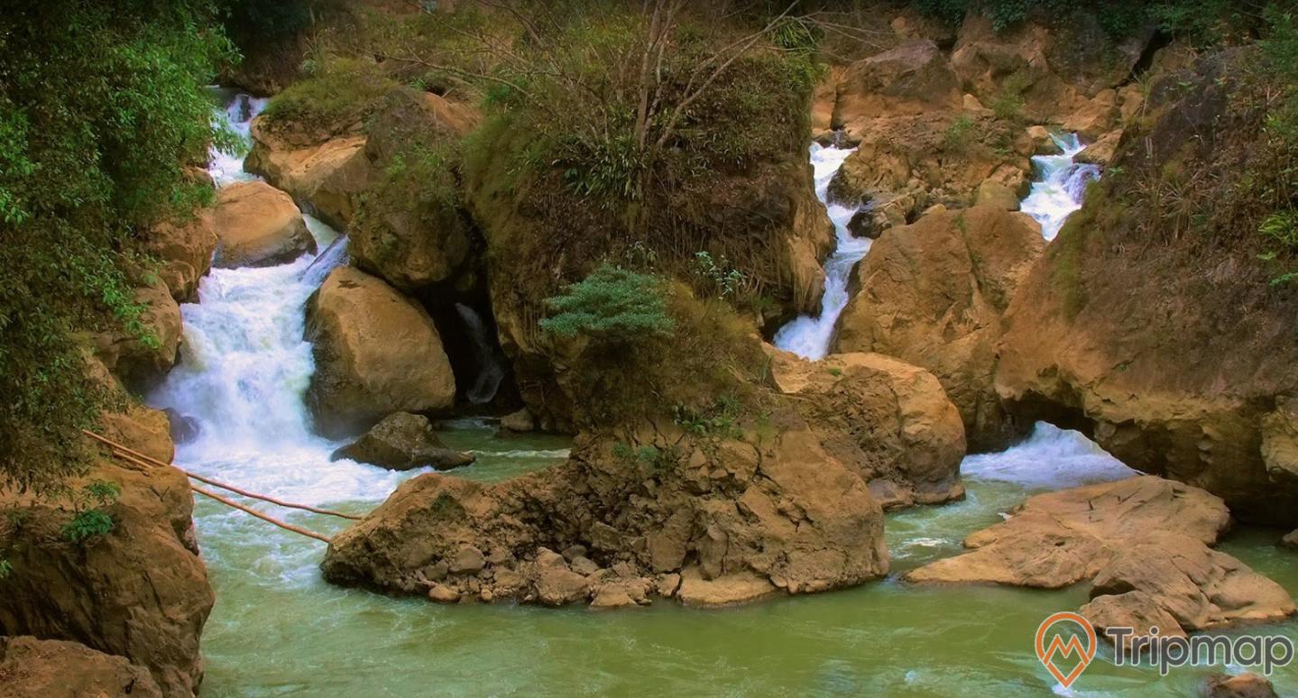 bức ảnh chụp gần thác đầu đẳng, thác nước đang chảy qua khe đá, cây mọc trên phiến đá cạnh thác nước, ảnh chụp ngoài trời