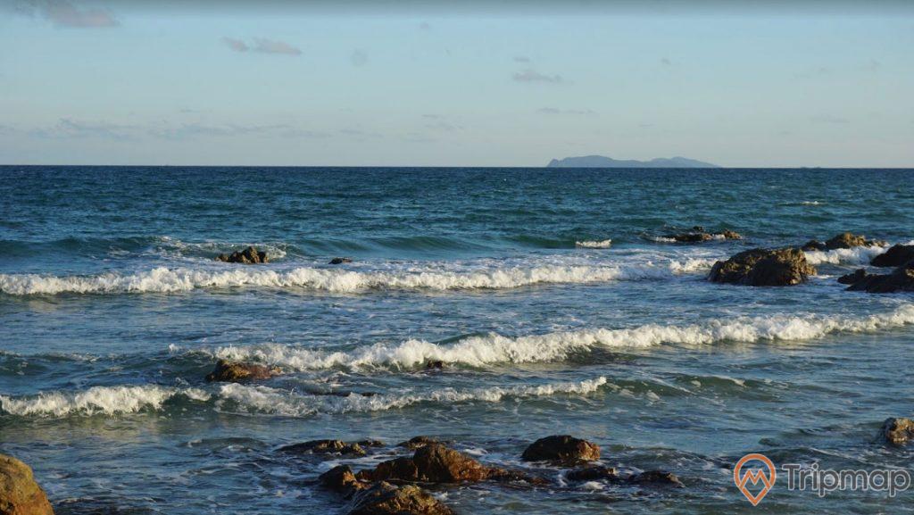Bãi tắm Robinson, nước biển màu xanh, sóng to, nhiều tảng đá to màu đen, trời xanh, ảnh chụp ban ngày