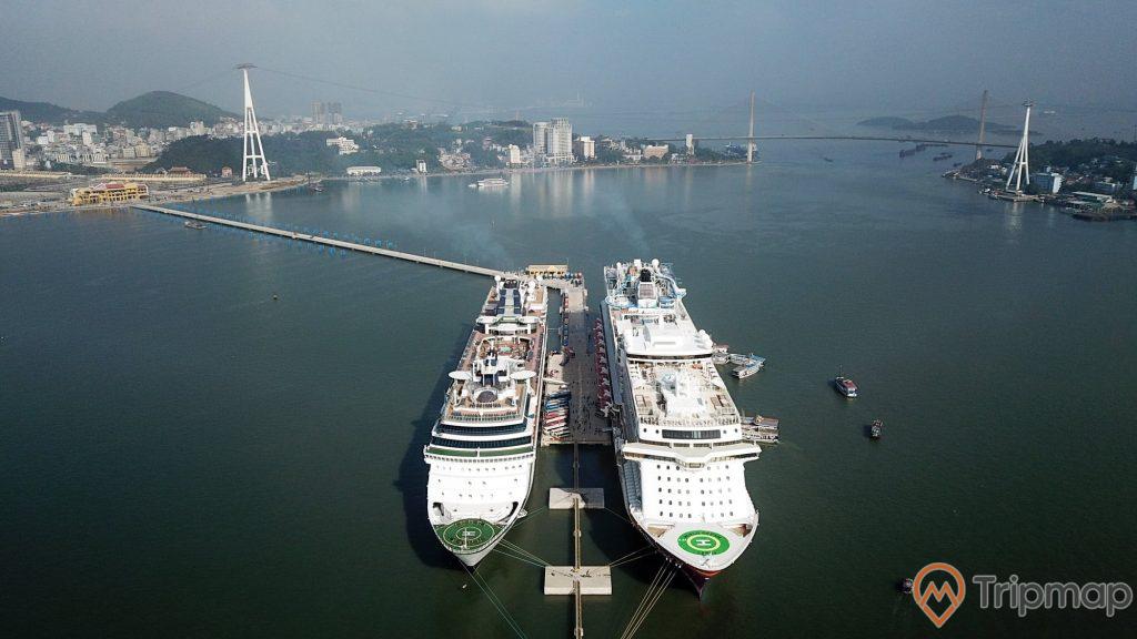 Cảng tàu khách Quốc tế Hạ Long, 2 tàu quốc tế 5 sao màu trắng, nước biển màu xanh, cầu bãi cháy ở phía xa, ảnh chụp từ trên cao, ảnh chụp ban ngày