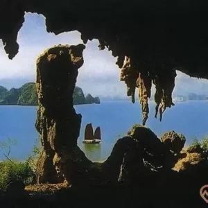 Hang Trống, vịnh Hạ Long, thuyền buồm, mặt nước biển màu xanh, nhiều ngọn núi đá phía xa, ảnh chụp ban ngày