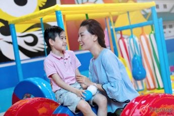 Khu vui chơi trẻ em KIDOLAND, người phụ nữ mặc áo xanh đang cầm tay cậu bé mặc áo hồng