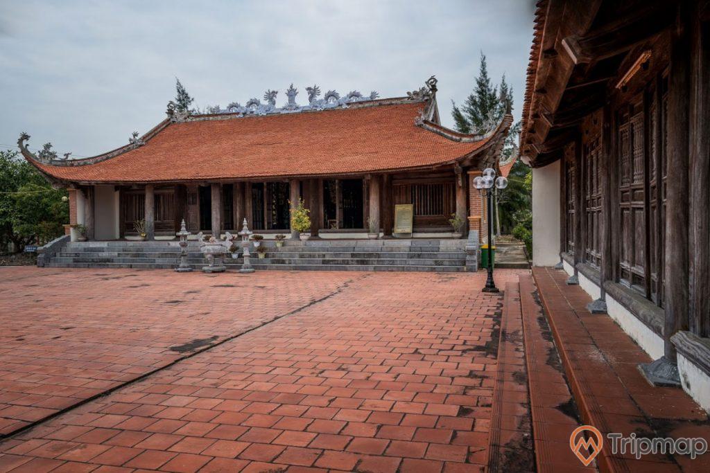Miếu thờ Trần Khánh Dư, nền gạch màu đỏ, mái ngói màu đỏ, trời nhiều mây, ảnh chụp ban ngày