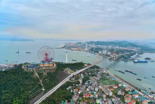 Sun Wheel , Vòng quay Mặt trời, vòng quay màu đỏ, nhiều cây xanh, cầu Bãi Cháy, khu dân cư ở phía xa, nhiều thuyền đang chạy trên sông, ảnh chụp ban ngày, ảnh chụp từ trên cao, trời nhiều mây