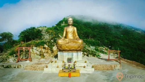 Tượng Phật hoàng Trần Nhân Tông, Yên Tử, tượng bằng đồng, chuông đồng, ngọn núi nhiều cây xanh phía xa, trời nhiều mây, ảnh chụp ban ngày