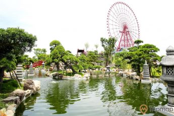 Vườn Nhật Bản Zen Garden, hồ nuôi cá Koi, nhiều cây xanh, vòng quay mặt trời ở phía xa, ảnh chụp ban ngày