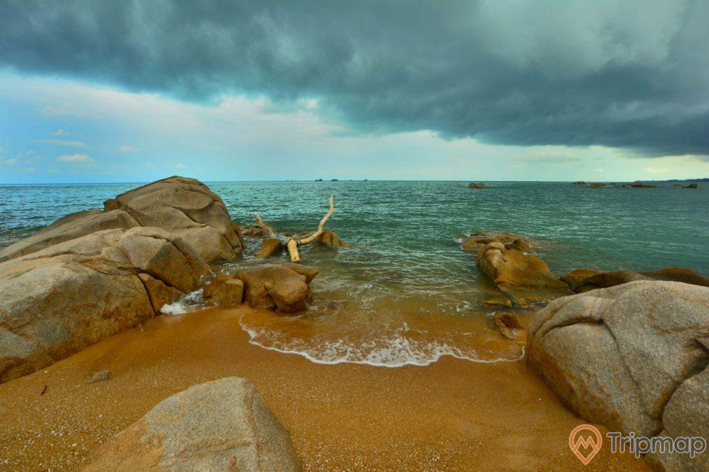 Bãi biển Ba Châu, nhiều tảng đá to màu xám, trời xanh nhiều mây đen, mặt nước biển màu xanh, ảnh chụp ban ngày