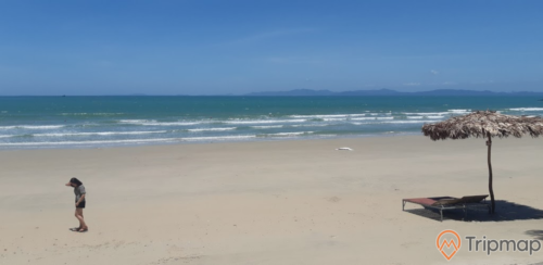 Quang cảnh buổi trưa nắng tại bãi biển Tình Yêu, bầu trời trong xanh, chiếc ô lá cọ và chiếc giường xếp trên bài biển, bãi cát và biển cô tô