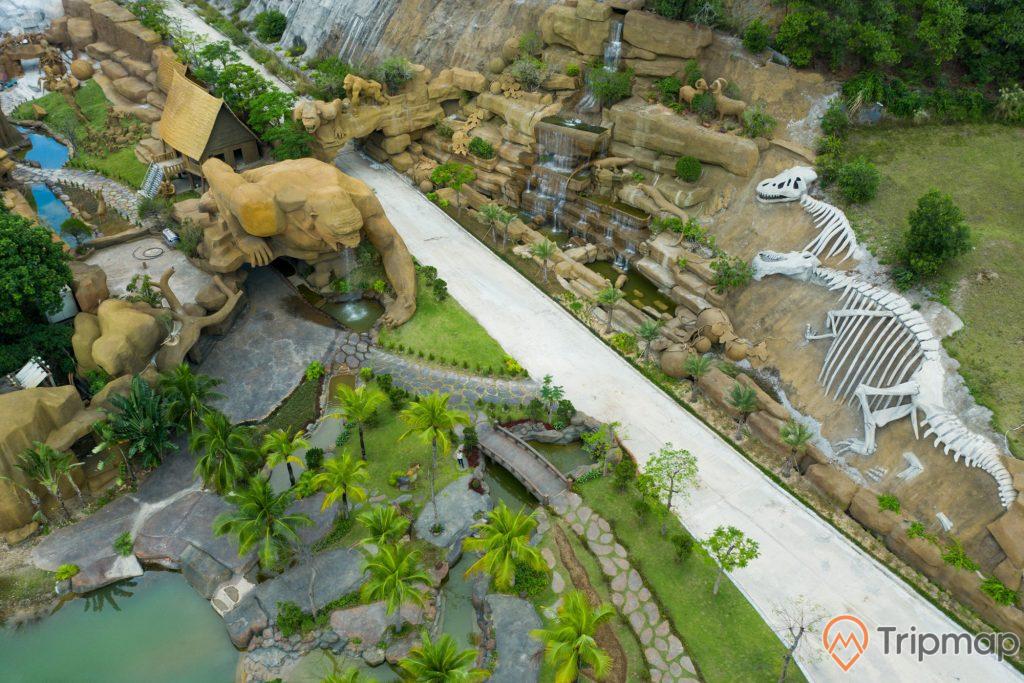 Toàn cảnh khuôn viên công viên King Kong tại đảo Tuần Châu, tượng hình xương khủng long màu trắng, những bức tượng King Kong và động vật bằng bê tông, cây cối xanh tươi, ảnh chụp từ trên cao