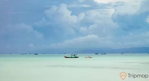 Những chiếc thuyền đang đi ngoài biển gần đảo Cô Tô con, bầu trời nhiều mây, ảnh chụp ngoài trời