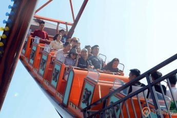 Tàu Hải Tặc, nhiều người đang ngồi trên hàng ghế màu cam, trời nắng, ảnh chụp ban ngày