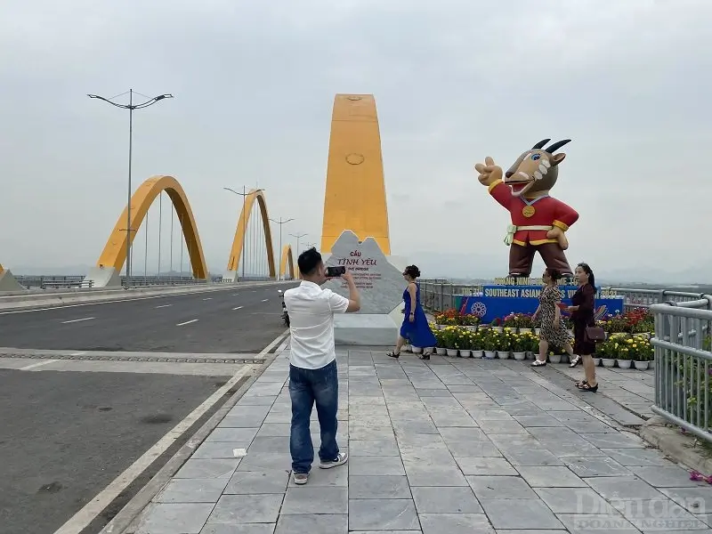 Du khách đến du lịch và chụp ảnh lưu niệm tại cầu Tình Yêu