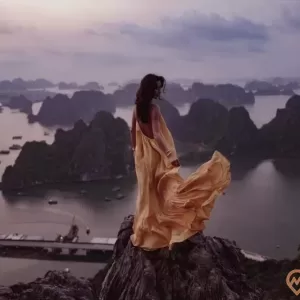 a person sitting on a rock overlooking a city