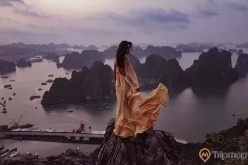 a person sitting on a rock overlooking a city