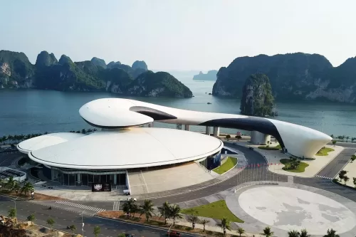 a building with a curved roof by the water