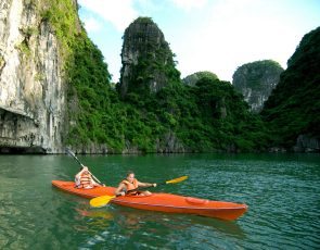 a couple of people in kayaks in a river with large rocks