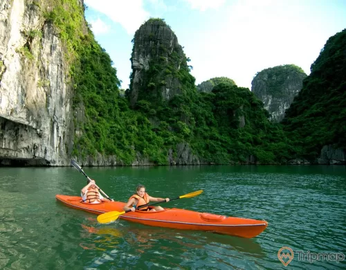 a couple of people in kayaks in a river with large rocks