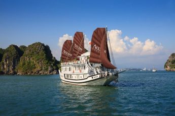 a large ship in the water with Ha Long Bay in the background