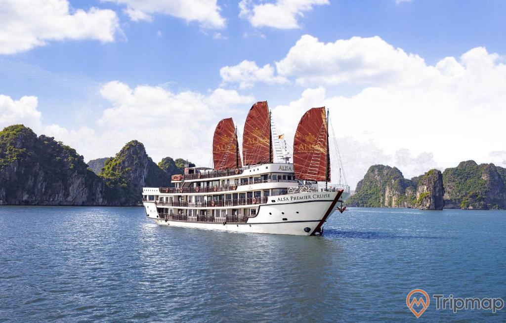 a large white boat on water with Ha Long Bay in the background