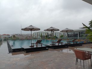a pool with umbrellas and chairs by a building